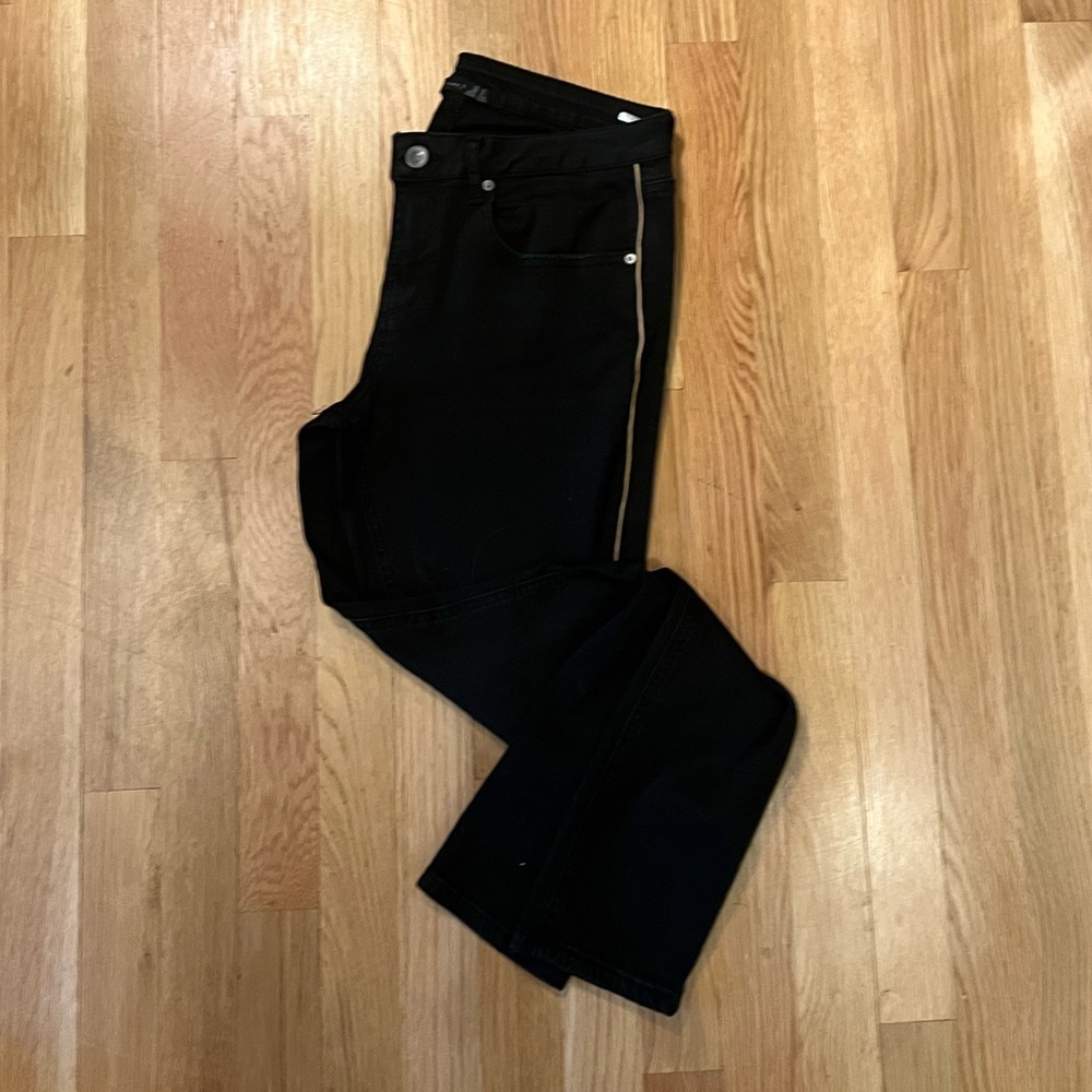 Black tape skinny jeans with thin gold stripe down the hip.